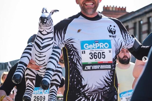 A runner in the bath half marathon in WWF top and holding an inflatable zebra