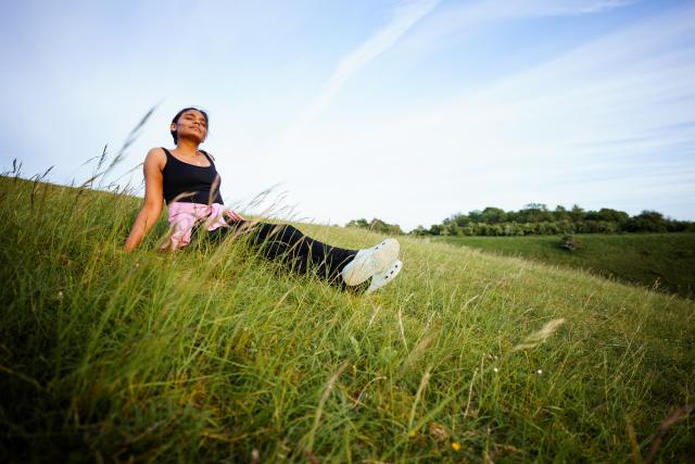 Woman relaxing on a grassy hill