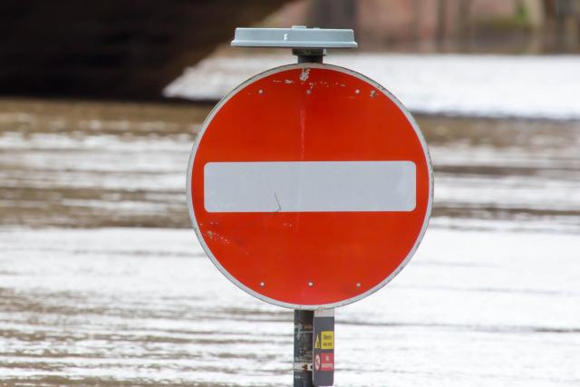 Stop sign submerged in flood near bridge in UK