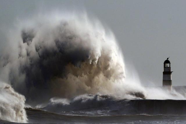 Waves crash against the light house in County Durham 