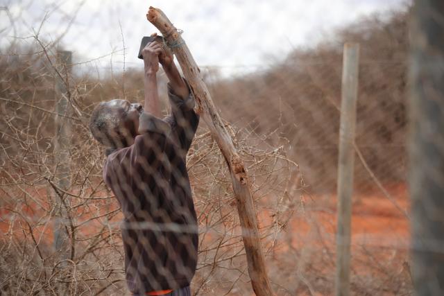 Andrew Lombo fixes a Lion Light on his livestock shed.  © Karuri Nyaga / Hushed Hills Ltd. / WWF-Kenya