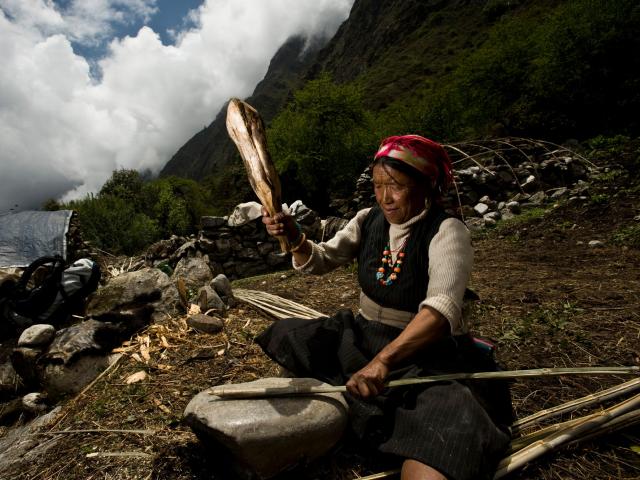A local woman splitting bamboo