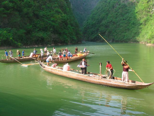 Tujia boatmen steering canoes through a gorge