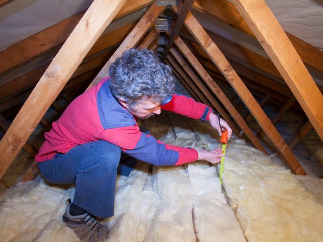 Man fits insulation to a home