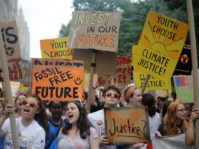 Young people holding placards and marching for climate justice