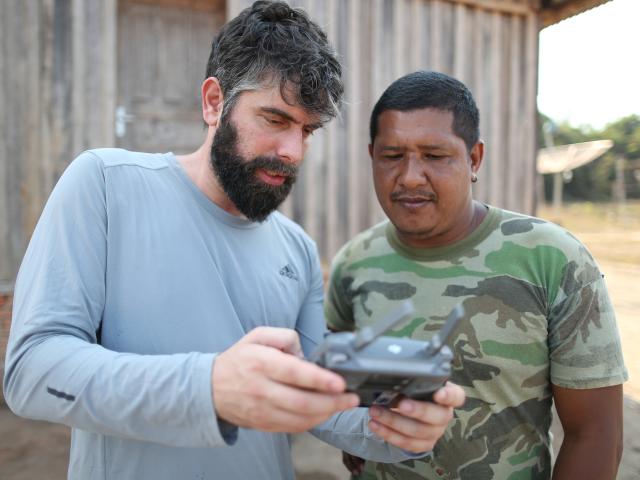  The WWF-Brasil Conservation Analyst Henrique Santiago teaches the Jahui leader, Nilcélio Jahui, how to operate a drone. Scene registered at the Jahui village, in the city of Manicoré.
