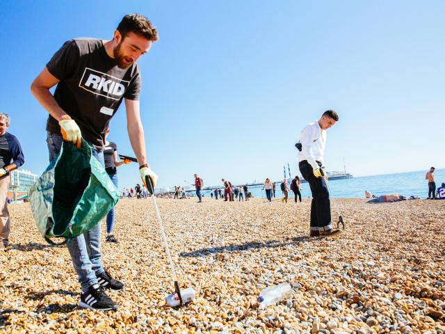 People picking litter on a beach