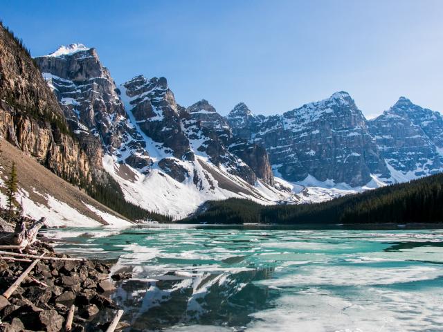 Snow covered mountains by an icy lake. 