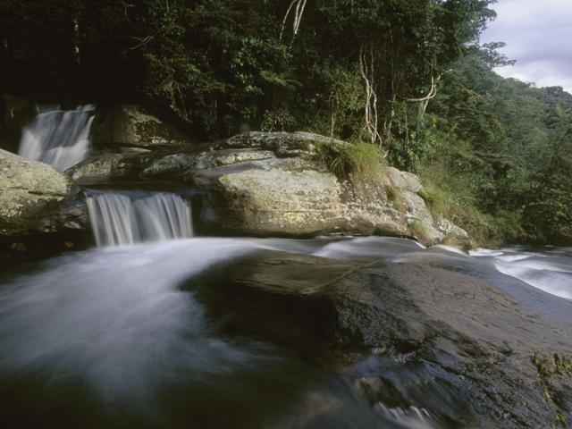 A view from the Sanje waterfall in the Udzungwa Mountains National Park, over sugar cane fields to the Selous Game Reserve, Tanzania
