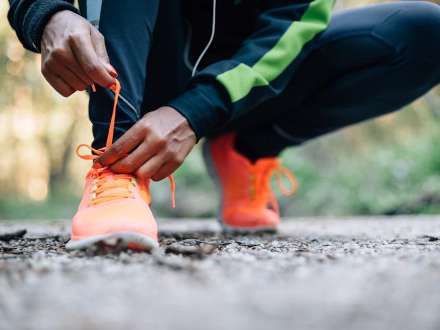 A man lacing his bright orange trainers 