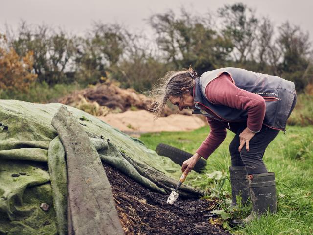 Liz tends to the natural compost created on the farm.