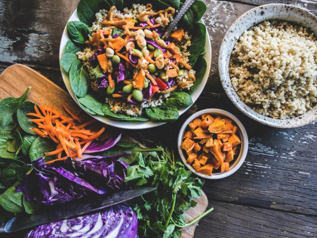 Healthy looking bowl of food including carrots, cabbage, salad leaves and quinoa.