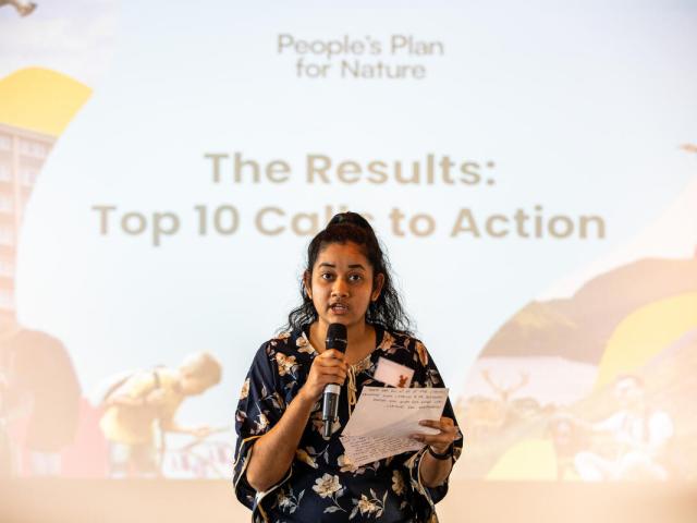 Woman speaking into a microphone at the People’s Assembly for Nature