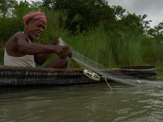 A fisher in a boat deploying the 'pinger'