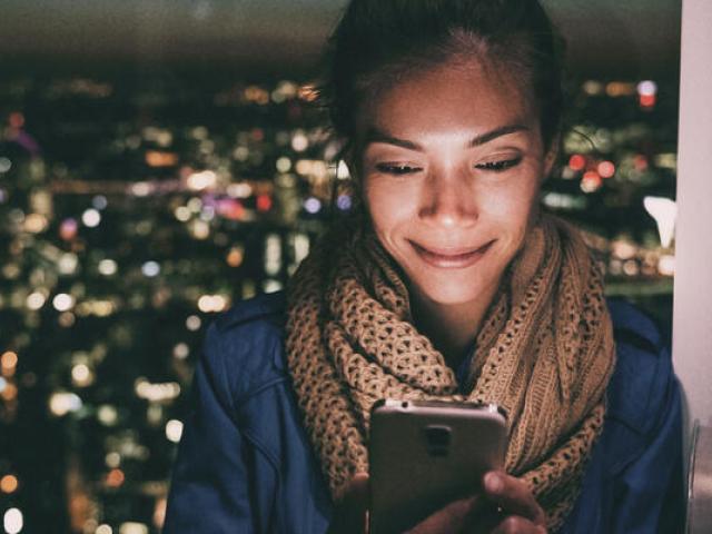 Person looking at phone with city backdrop