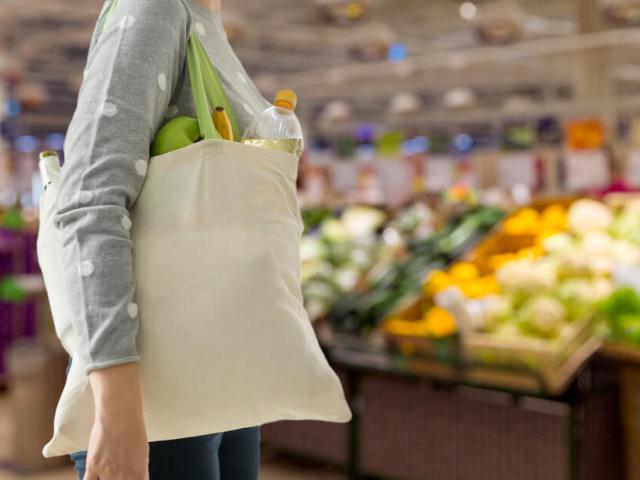 Person carrying shopping bag in supermarket
