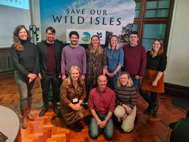 The WWF Cymru team pictured in front of a Save Our Wild Isles board at an event.