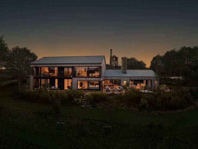 Omaze Cornwall house exterior, outside at night with the sun setting taken at from a raised viewpoint
