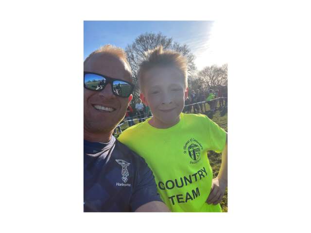 A man in sunglasses and a small boy in a yellow shirt smiling