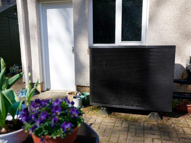Daikin heat pump with flowers in the forefront of the image