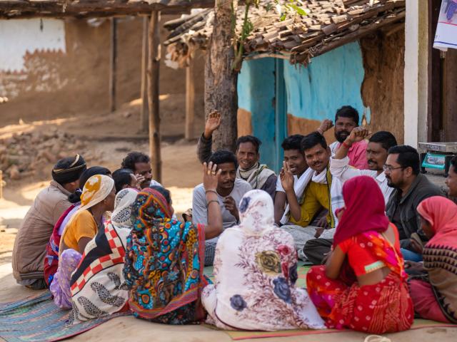 A group of people sat together in a community in India