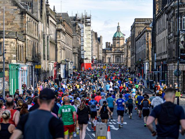 Runners running down the royal mile in Edinburgh