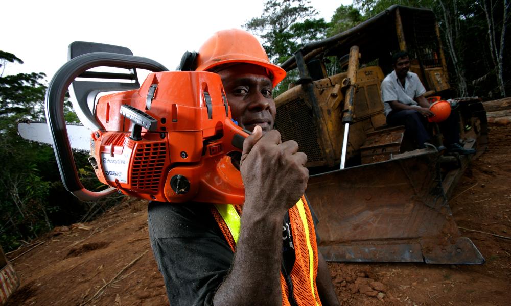 A portrait of a logger holding a chainsaw