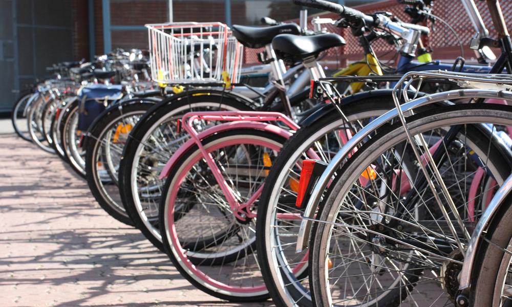 A row of bicycles outside a building in an urban city setting.