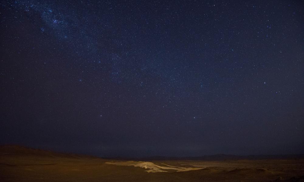 Night stars with ligh reflexion on the desert. Paracas National Park, Ica region, Peru