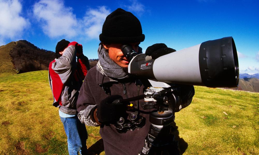 Members of OCL, watching and photographing Cranes (Grus grus) with cameras and binoculars migrating over Organbidexka Col, the Pyrenees, France.