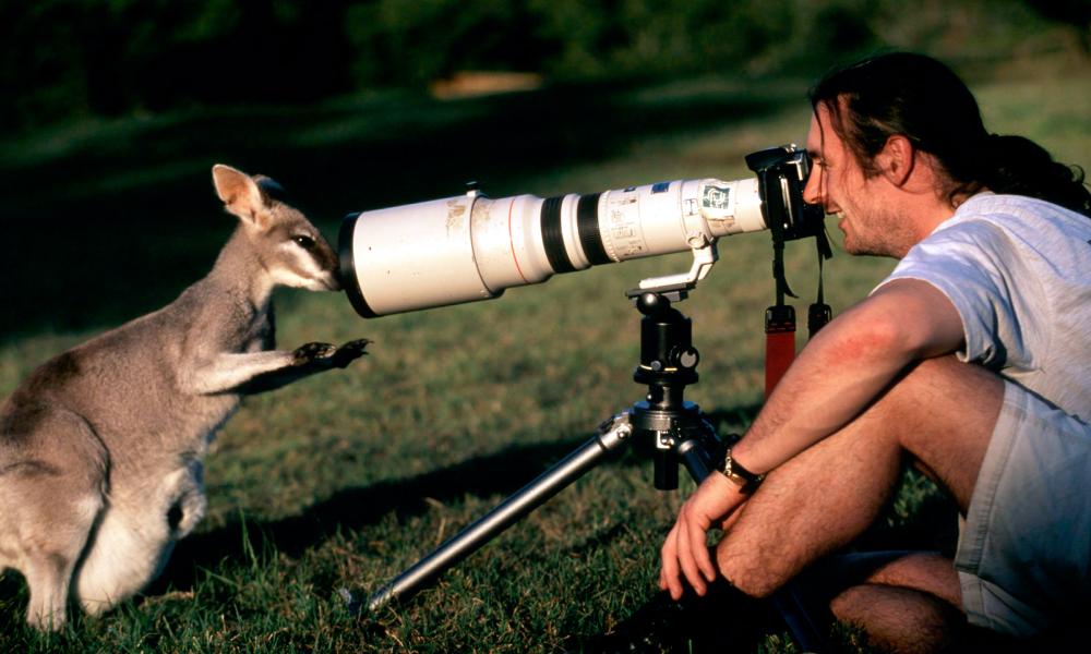 Assistant photographer, Tony Heenon, working with Canon camera equipment, gets eye to eye with a kangaroo, Australia.