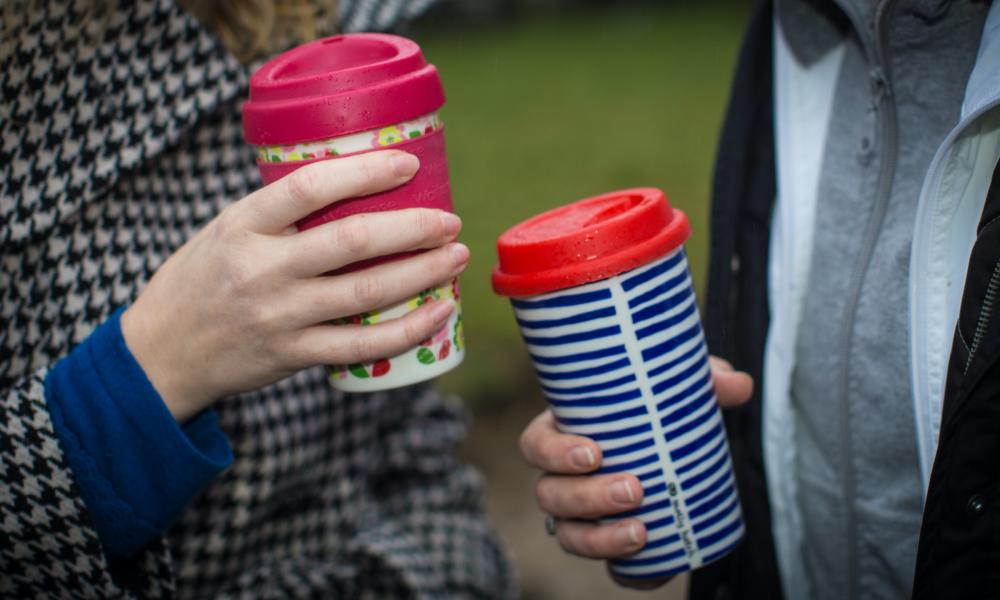 Coffee drinkers carry a reusable coffee cup in Berkhamsted, England.