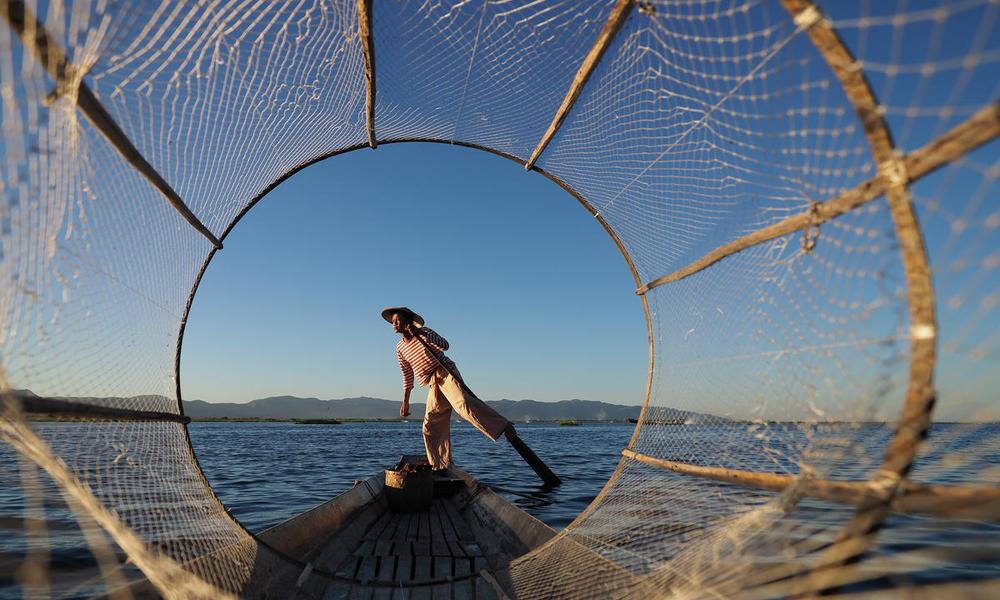 Basket fisherman poses for a frame, Inlay Lake, Myanmar