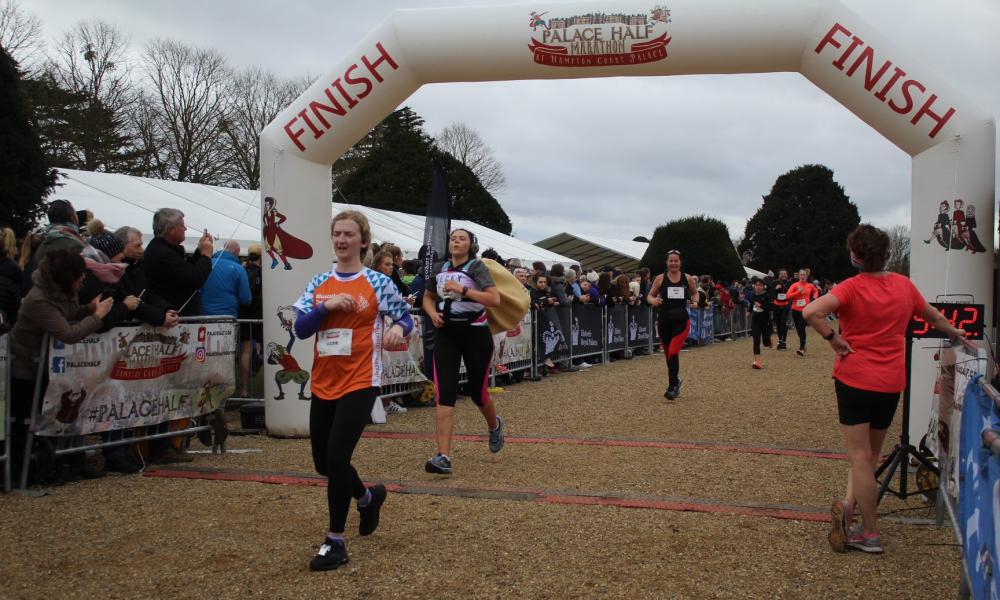 A few people are crossing the finish line of a half marathon in winter