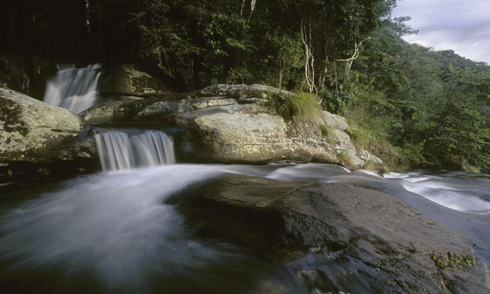 A view from the Sanje waterfall in the Udzungwa Mountains National Park, over sugar cane fields to the Selous Game Reserve, Tanzania