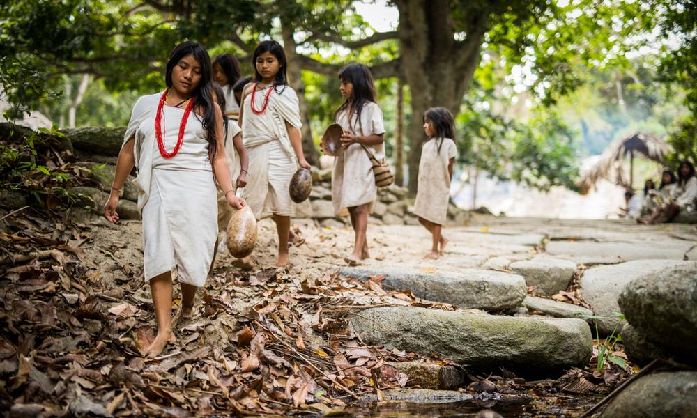 Kogi children walking along a small stream in the Tayrona National Park of Colombia.