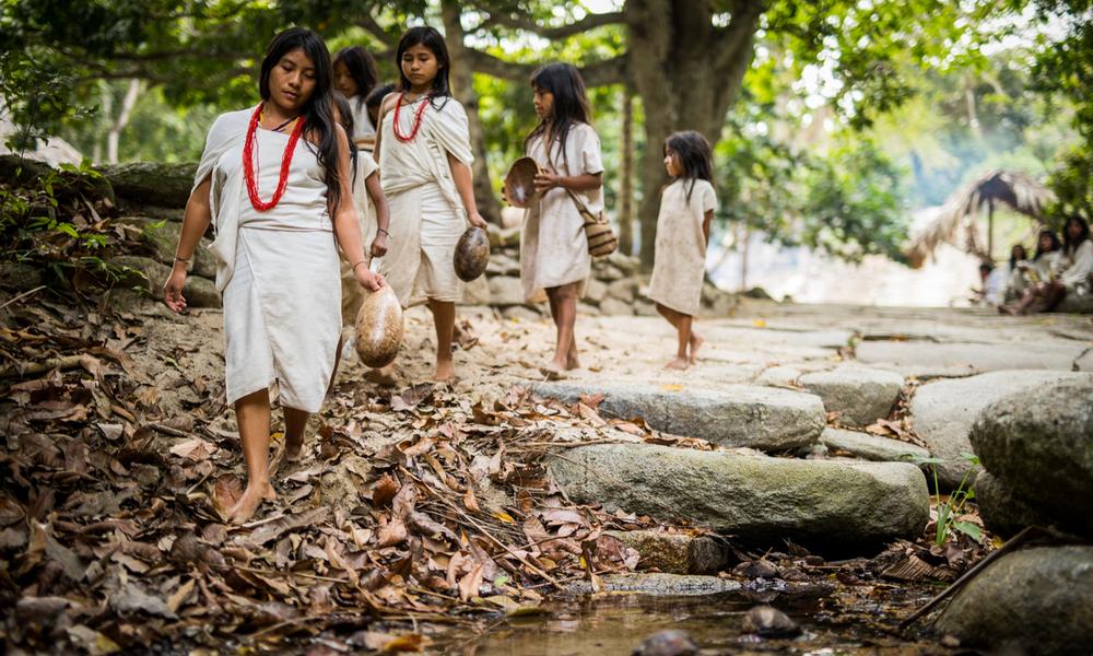Kogi children walking along a small stream in the Tayrona National Park of Colombia.