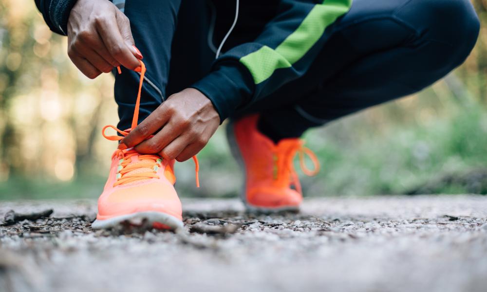 A man lacing his bright orange trainers