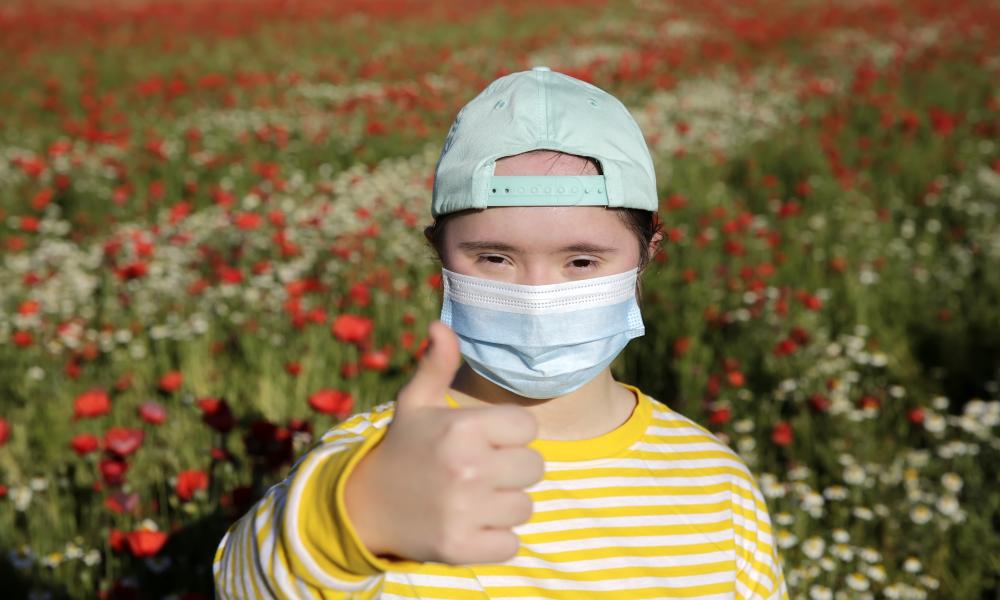 Boy wearing face mask with thumbs up