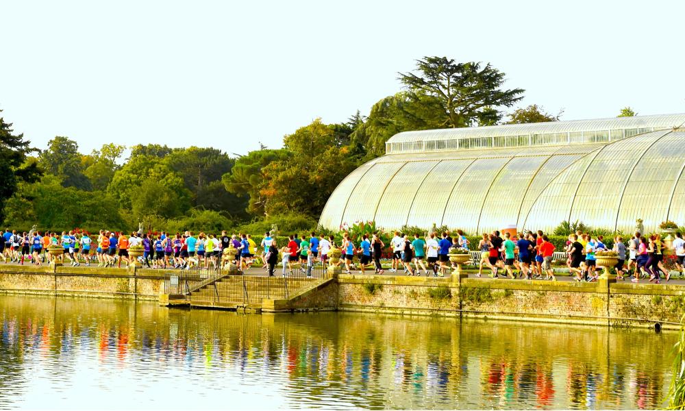 Runners passing the Palm building at Kew Gardens
