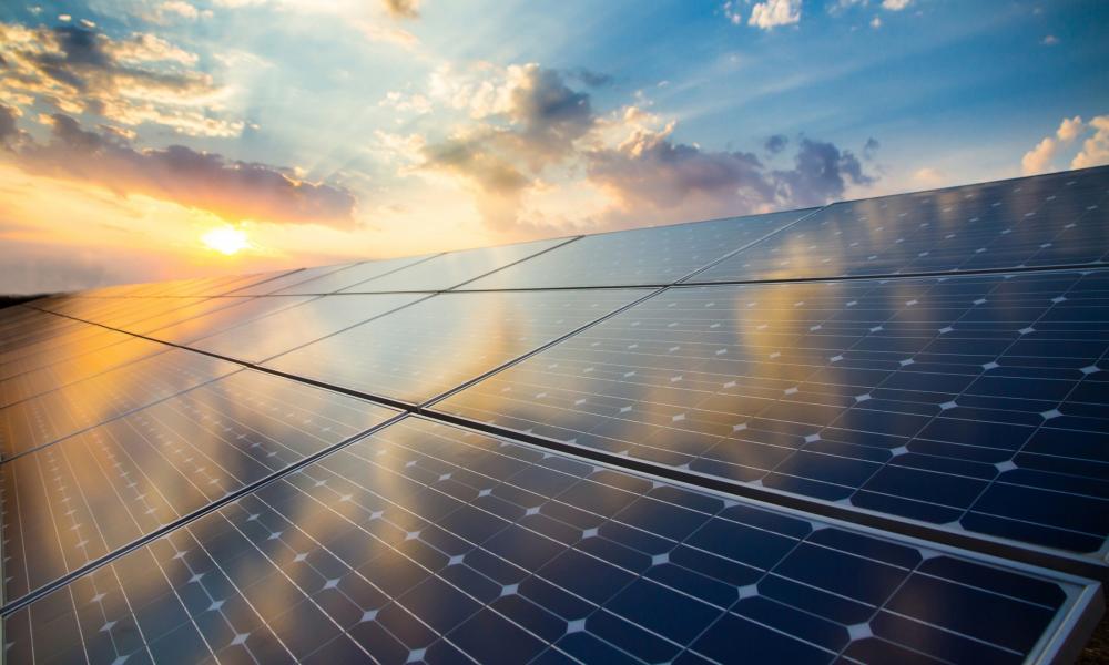 Renewable energy stock image of photovoltaic modules on the background of sunset and cloudy sky. 