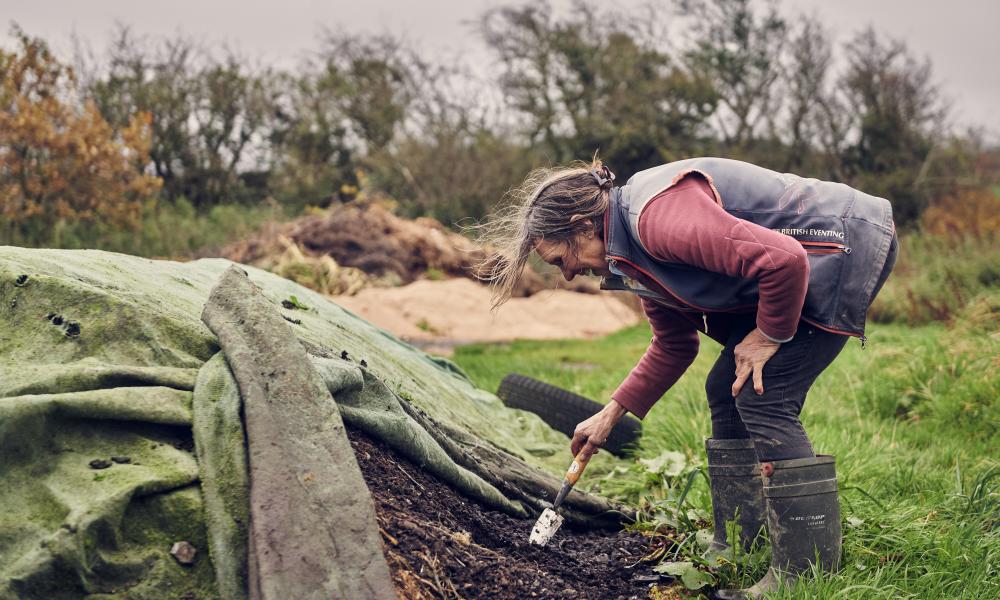 Liz tends to the natural compost created on the farm.