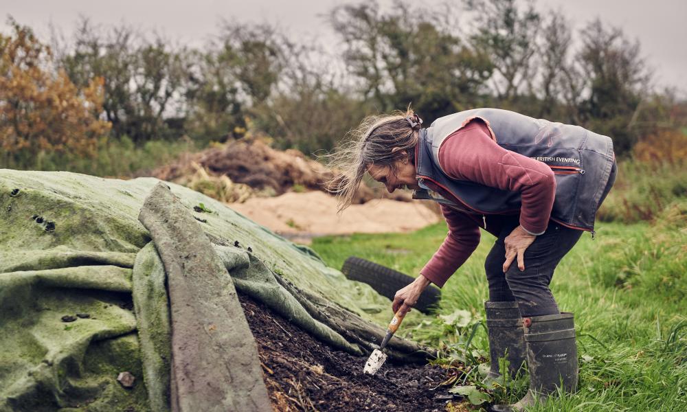 Liz tends to the natural compost created on the farm.