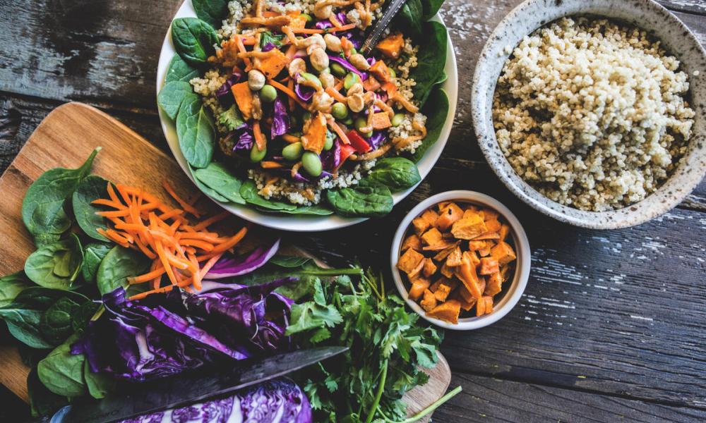 Healthy looking bowl off food including carrots, cabbage, salad leaves and quinoa.