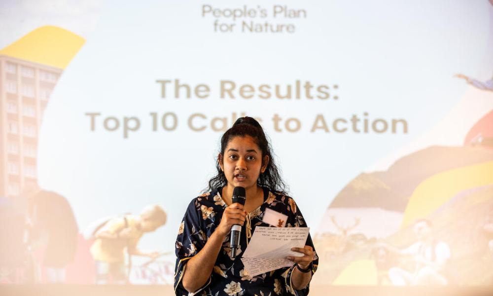 Woman speaking into a microphone at the People’s Assembly for Nature