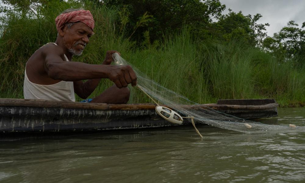 A fisher in a boat deploying the 'pinger'