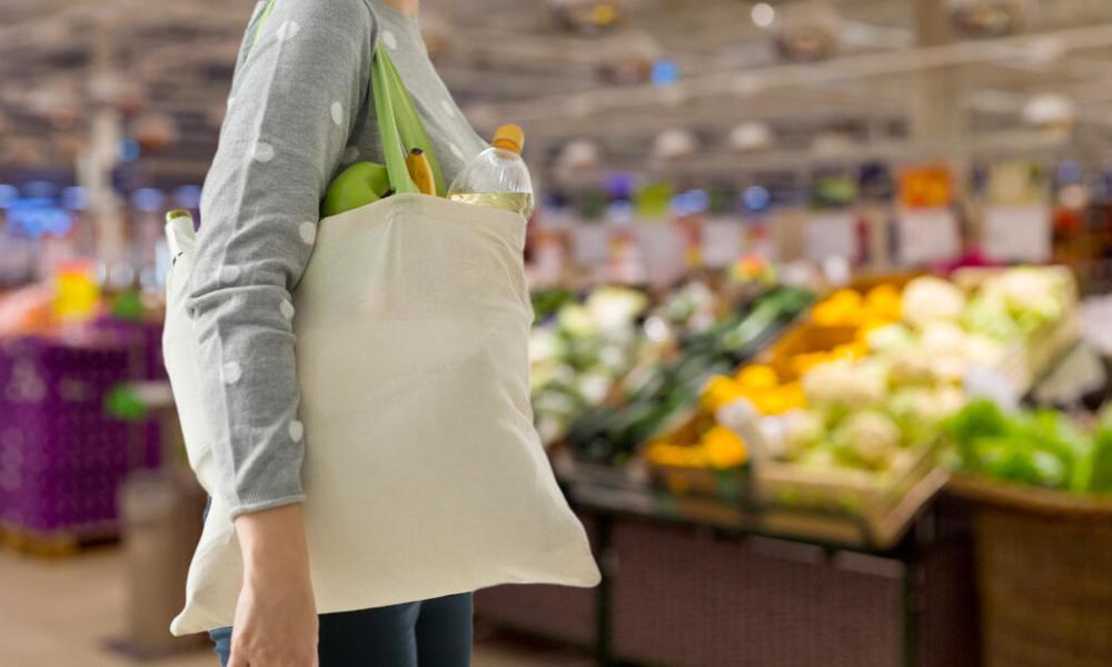 Person carrying shopping bag in supermarket - © Shutterstock.jpg