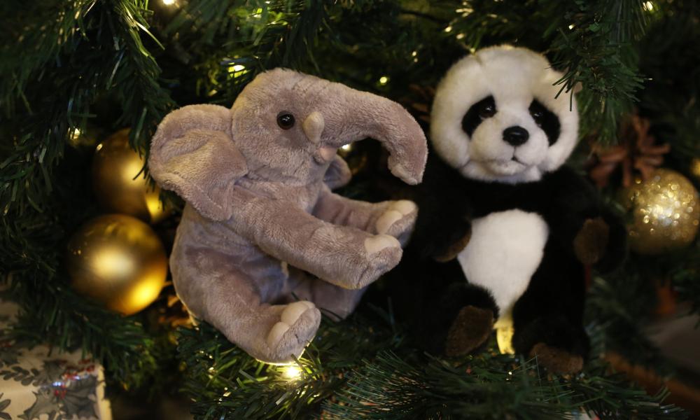 Elephant and panda plush toys in a Christmas tree