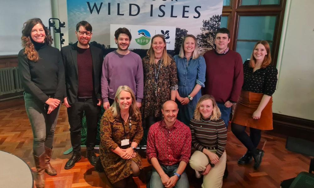 The WWF Cymru team pictured in front of a Save Our Wild Isles board at an event.