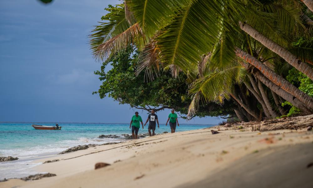 Tuvuca Island, WWF-Pacific volunteers Adi Fulori, Sevanaia Koroisamani and Melea Rakavu [left-right] taking a walk along the beach.